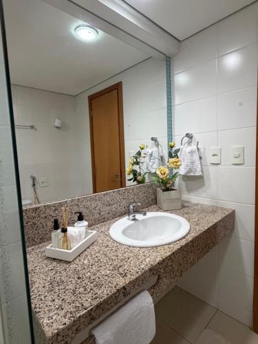 a bathroom with a sink and a mirror at Flat Moderno no Blue Tree Hotel in Manaus