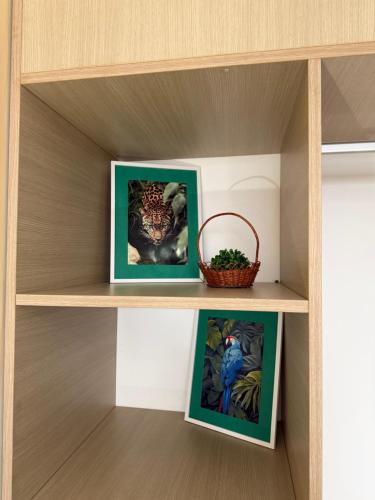 a shelf with two pictures and a basket on it at Flat Moderno no Blue Tree Hotel in Manaus