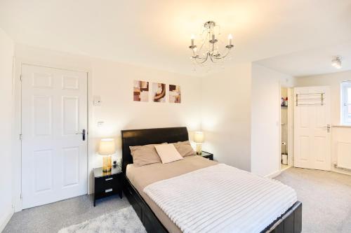 a bedroom with a large bed and a chandelier at Lavish Lodge - Perfect for couples, families and contractors! in Wakefield