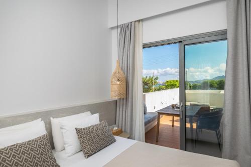 a bedroom with a bed and a view of a balcony at Etherio Suites Milos in Pollonia