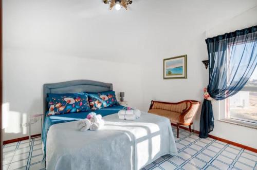 a bedroom with a blue bed with two stuffed animals on it at Due Passi Dal Mare in Torre a Mare