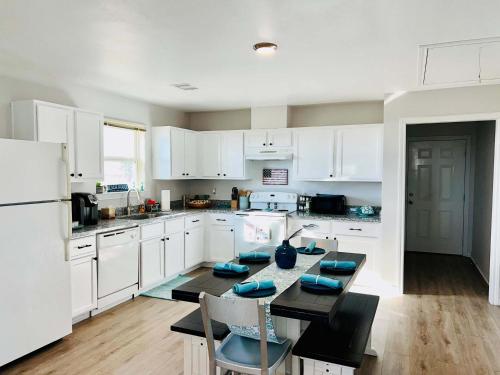a kitchen with white cabinets and a table and chairs at Pelican Pointe Home for 10 in Bolivar Peninsula