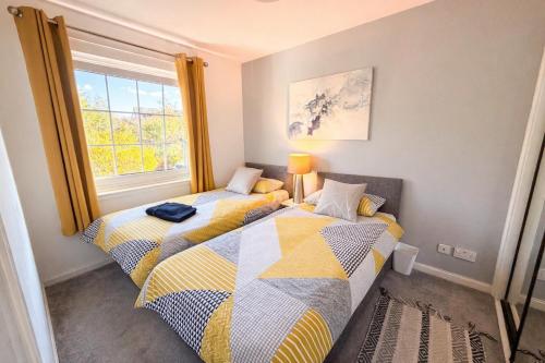 two beds in a room with a window at Inverness Holiday Retreat - 2 Bedroom in Inverness