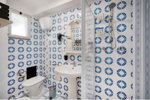 a blue and white bathroom with a sink and a toilet at Due Passi Dal Mare in Torre a Mare