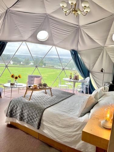 a bedroom with a large bed in a tent at The Dome at Midauchengowan in Lochwinnoch