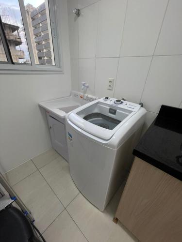 a white washing machine in a room with a window at Cantinho da Lyah in Torres