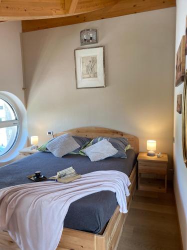 a bedroom with a bed with blue sheets and two lamps at APPARTAMENTO MONTE - VALANDRO- in Comano Terme