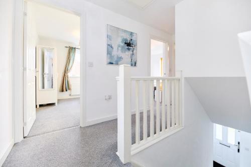 a white staircase in a white room with white walls at Lavish Lodge - Perfect for couples, families and contractors! in Wakefield