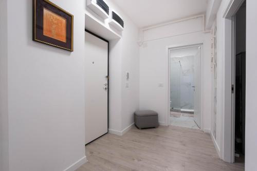 a hallway with white walls and a picture on the wall at Ivory Luxury 1BR in Voluntari