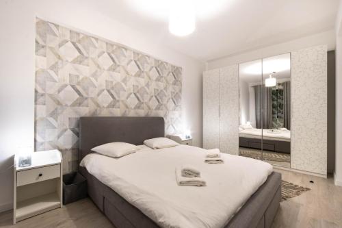 a bedroom with a large bed and a mirror at Ivory Luxury 1BR in Voluntari