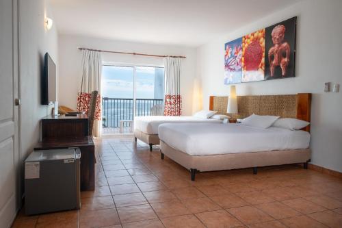 ein Hotelzimmer mit zwei Betten und Balkon in der Unterkunft Royal Decameron Salinitas - All Inclusive in Los Cóbanos