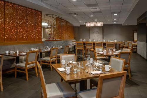 a dining room with wooden tables and chairs at Crowne Plaza Chicago Ohare Hotel & Conf Ctr by IHG in Rosemont