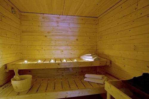 a wooden sauna with a bench and towels in it at Sauna Chata BedRich in Bedřichov