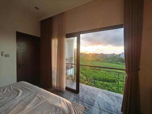 a bedroom with a large window with a view at Santo Guesthouse in Canggu