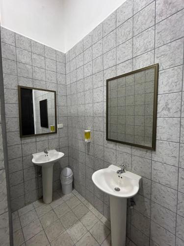 a bathroom with two sinks and a mirror at Casa 12-87 in Poneloya
