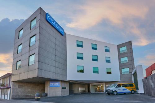 a building with a car parked in a parking lot at City Express by Marriott Ciudad de Mexico Aeropuerto in Mexico City