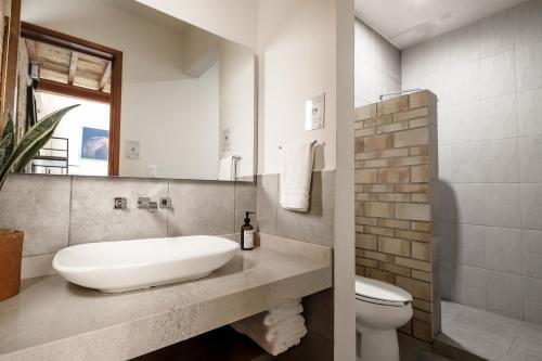 a bathroom with a sink and a toilet and a mirror at Bungalows in Samsara Atlixco in La Sabana