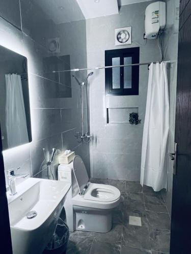 a bathroom with a white toilet and a sink at Modern Apartment 3 in Jeddah