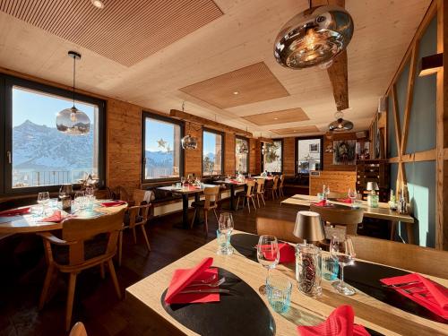 a restaurant with tables and chairs with mountains in the background at Berggasthaus Eggberge - Boutique Mountain Hotel - Access via Cablecar in Altdorf