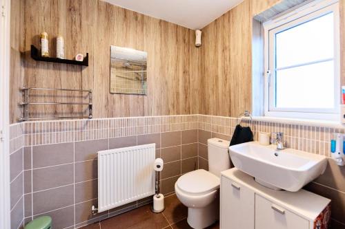 a bathroom with a white toilet and a sink at Lavish Lodge - Perfect for couples, families and contractors! in Wakefield