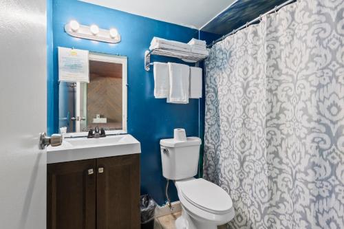 a blue bathroom with a toilet and a sink at Oceanfront Inn Room #9 in Fort Pierce