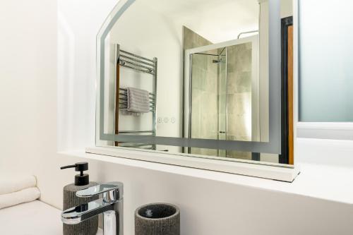 a bathroom with a sink and a mirror at Brand New 3-Bed House - Walk to Stone Town Centre! in Stone