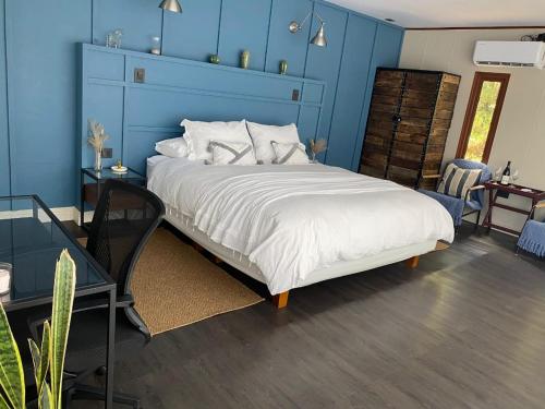 a bedroom with a large bed with a blue wall at Nidos de Apalta in Santa Cruz