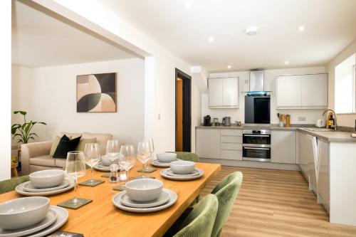 a dining room and kitchen with a table and chairs at Brand New 3-Bed House - Walk to Stone Town Centre! in Stone