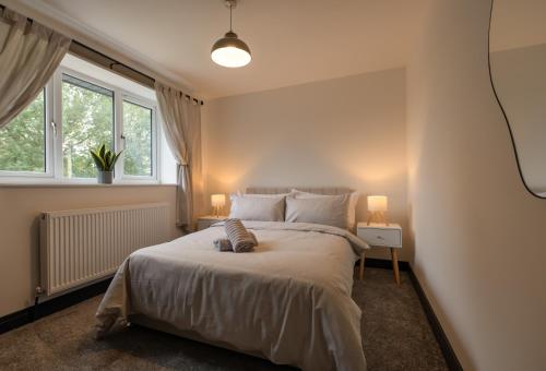 a bedroom with a large bed with two lamps at Brand New 3-Bed House - Walk to Stone Town Centre! in Stone