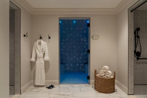 a dressing room with a white suit and a blue shower at La Bahia Hotel & Spa in Santa Cruz