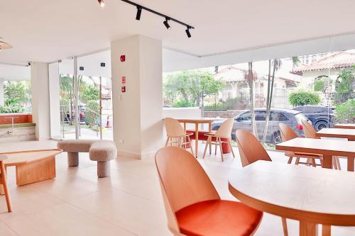een restaurant met tafels, stoelen en ramen bij Edificio Doña Raquel in Panama-Stad