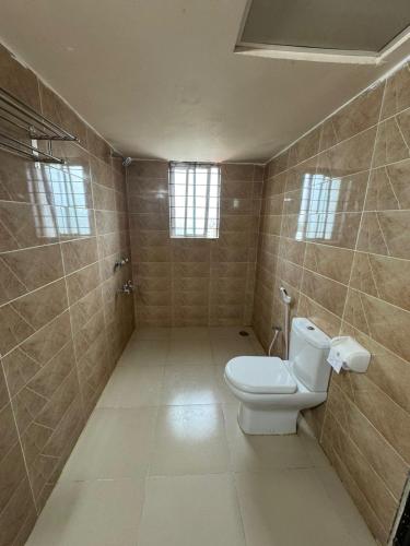 a bathroom with a toilet and tiled walls at Hotel Istanbul Sylhet in Sylhet