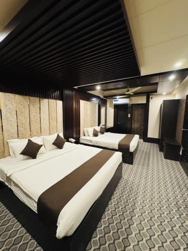 a hotel room with two beds and a television at Hotel Istanbul Sylhet in Sylhet