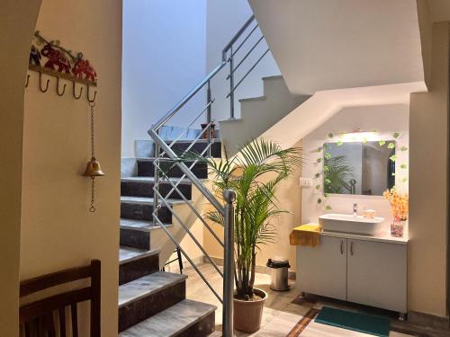 a bathroom with a staircase with a sink and a mirror at Ayu Aanandam - Live I Heal I Rest in Rishīkesh