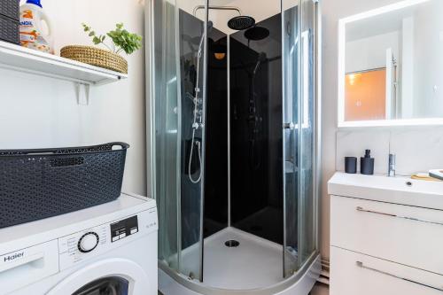 a shower in a bathroom with a washing machine at Cosy Home proche RER in Noisy-le-Grand