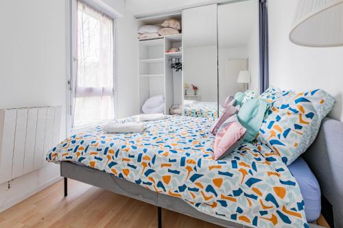 a bedroom with a bed with a colorful comforter at Cosy Home proche RER in Noisy-le-Grand