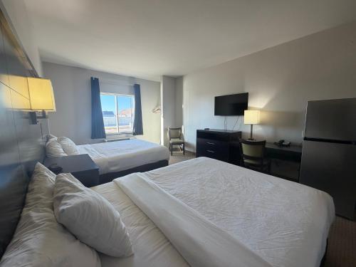 a hotel room with two beds and a desk at Black Gold Suites Stanley in Stanley