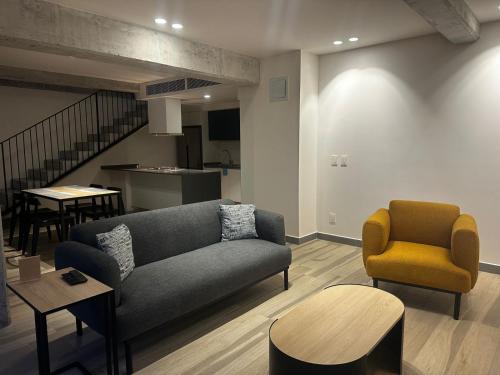 a living room with a couch and a chair at Nido x Nomad Pablo Neruda GDL in Guadalajara