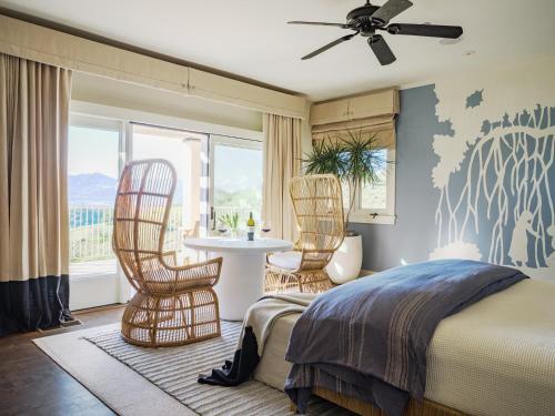 a bedroom with a bed and two chairs and a table at Sttupa Estate Napa Valley in Napa