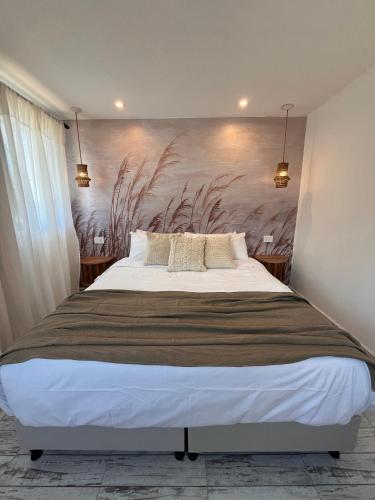 a bedroom with a large bed with a painting on the wall at Boho Suites in Tafí del Valle