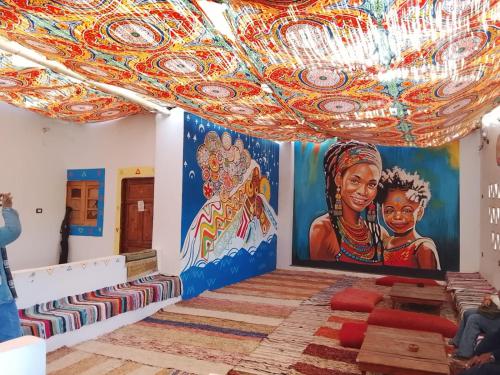 a room with paintings on the walls and a chandelier at Mostafa Gest House in Asyut