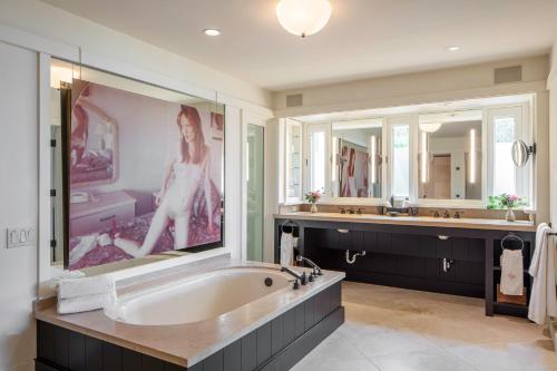 a large bathroom with a large painting of a woman at Sttupa Estate Napa Valley in Napa