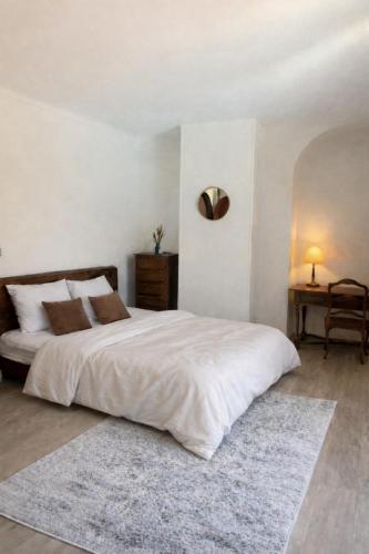 a bedroom with a large white bed with a rug at Chambres de charme in Corte
