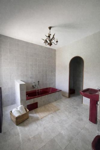 a large bathroom with a red tub and a table at Chambres de charme in Corte