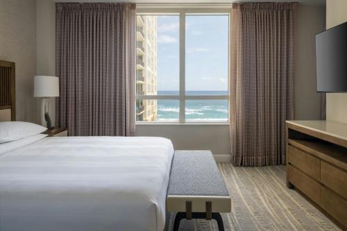 a hotel room with a bed and a large window at Palm Beach Marriott Singer Island Beach Resort & Spa in Palm Beach Shores