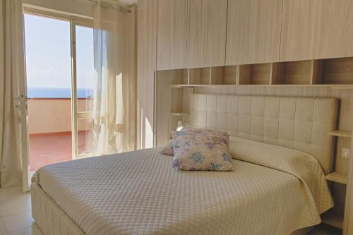 a bedroom with a bed with a view of the ocean at Villa Ginanneschi - Le Pitte in Capoliveri