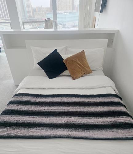 a bed with pillows on it in a room with a window at Birmingham Central NewStreet 1Bed in Birmingham