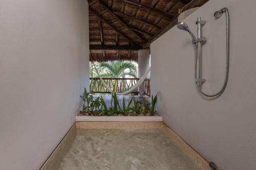 a walk in shower in a room with plants at Ana y Jose Tulum Hotel & Beach Club in Tulum