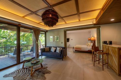 a living room with a bed and a bed and a room at Ana y Jose Tulum Hotel & Beach Club in Tulum