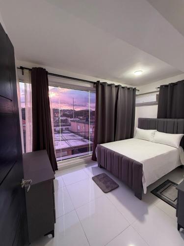 a bedroom with a bed and a large window at Moon Apartamentos C1 in San Cristóbal